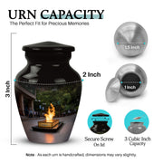 Glossy Black Campfire Cremation Urn close-up of engraving and surface detail - classic sculpted campfire pattern on smooth aluminum - mini keepsake memorial for portion of cremation ashes