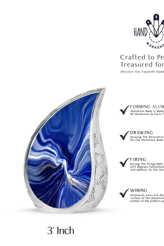 Soft Blue Blue Cremation Urn angled view of lid and engraved motif - smooth teardrop contour featuring blue art - mini keepsake memorial for portion of cremation ashes