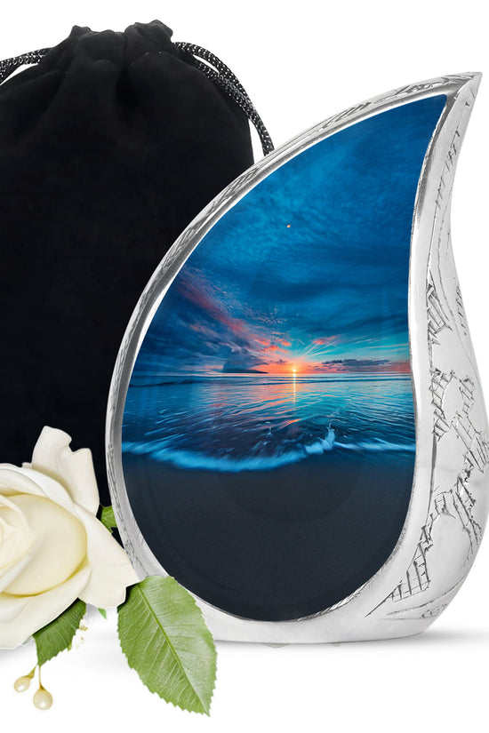 Pastel Blue Beach Cremation Urn front view showing detailed design - flowing teardrop beach silhouette on curved aluminum - full-size 10 inch 200 cubic inch adult cremation urn