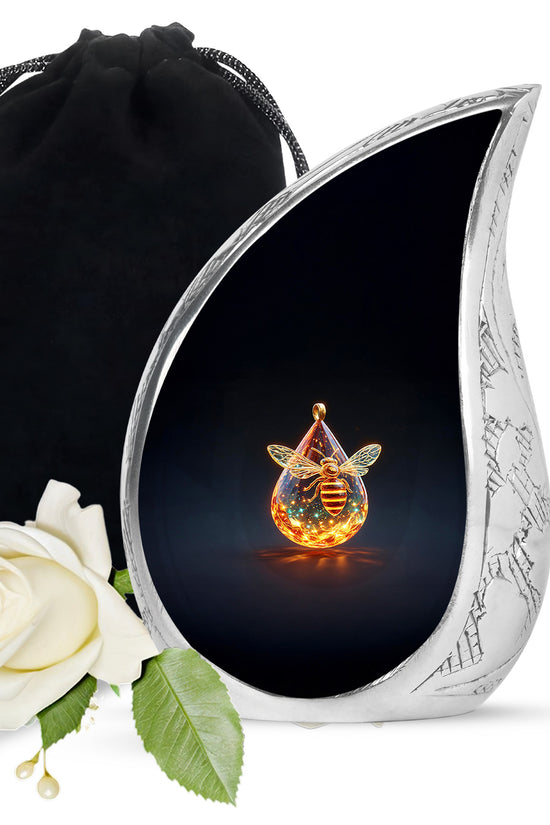Ebony Bee Cremation Urn front view showing detailed design - flowing teardrop bee silhouette on curved aluminum - full-size 10 inch 200 cubic inch adult cremation urn