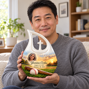 An adult holding the Cross Drop baseball memorial urn, with its personalized artwork visible.