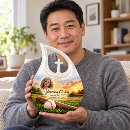 An adult holding the Cross Drop baseball memorial urn, with its personalized artwork visible.