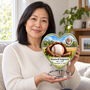 An adult holding the Heart baseball memorial urn, with its personalized artwork visible.