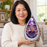 An adult holding the Straight Drop baseball memorial urn, with its personalized artwork visible.