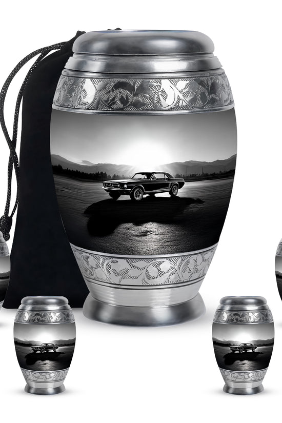 Charcoal Gray Car Cremation Urn detail view - ornate monarch-style car relief on brushed aluminum - memorial set with one large and four small urns