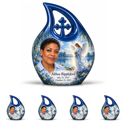 10 inch large Urn with 4 Keepsake 3 Inch Urns, Cross Drop angel beside quiet blue water memorial urn and Althea Rippleford photo and dates.