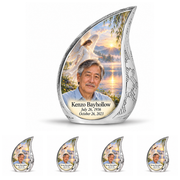 10 inch large Urn with 4 Keepsake 3 Inch Urns, Curved Drop angel beside quiet blue water memorial urn and Kenzo Bayhollow photo and dates.