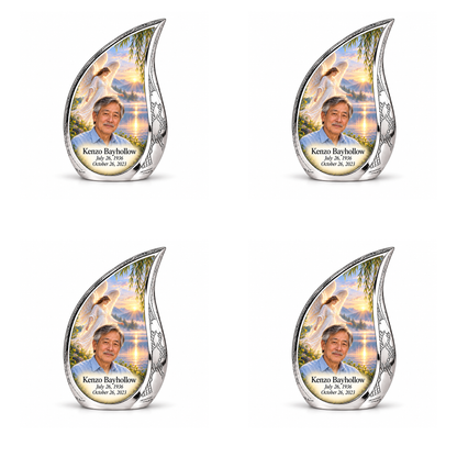 4 Keepsake 3 inch Urns, Curved Drop angel beside quiet blue water memorial urn and Kenzo Bayhollow photo and dates.