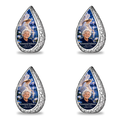 4 Keepsake 3 inch Urns Straight Drop memorial urn, angel beside quiet blue water, Rosamund Stillmere portrait and full memorial dates, white background.