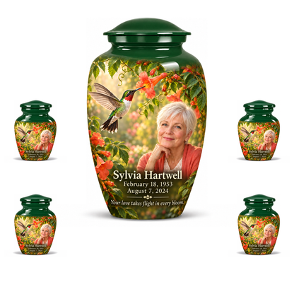 One 10-inch large urn with four matching 3-inch keepsakes, Classic ruby-throated hummingbird and coral trumpet-vine design with fictional Sylvia Hartwell portrait, name and full memorial dates on white background.