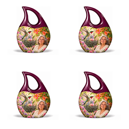Hummingbird 01 Cross Drop, 4 Keepsake 3 inch Urns: glossy mulberry-plum loop above a ruby-throated hummingbird, coral trumpet flowers and rose-lavender garden; fictional Celia Roswick portrait, name and full dates.