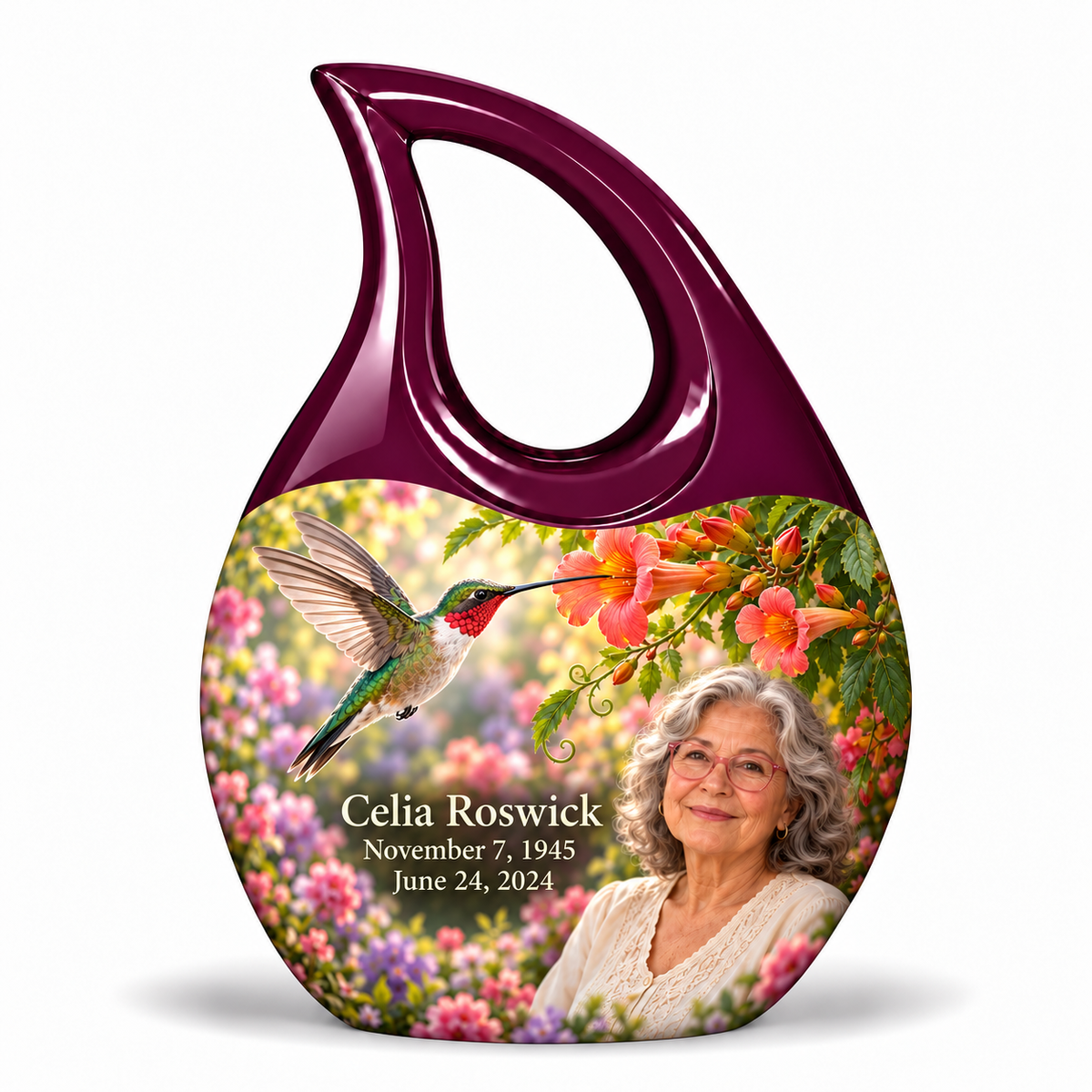 Hummingbird 01 Cross Drop, 1 Keepsake 3 inch Urn: glossy mulberry-plum loop above a ruby-throated hummingbird, coral trumpet flowers and rose-lavender garden; fictional Celia Roswick portrait, name and full dates.