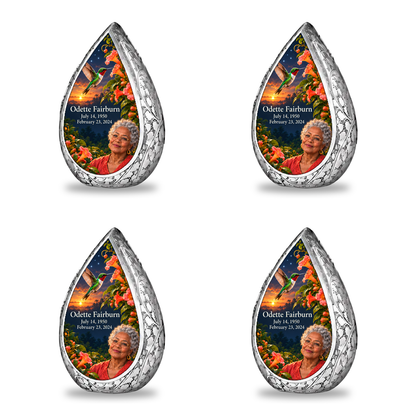 Hummingbird 01 Straight Drop, 4 Keepsake 3 inch Urns: original engraved silver frame surrounding a ruby-throated hummingbird, peach-coral trumpet vine and apricot-to-navy dusk; fictional Odette Fairburn portrait, name and full dates.
