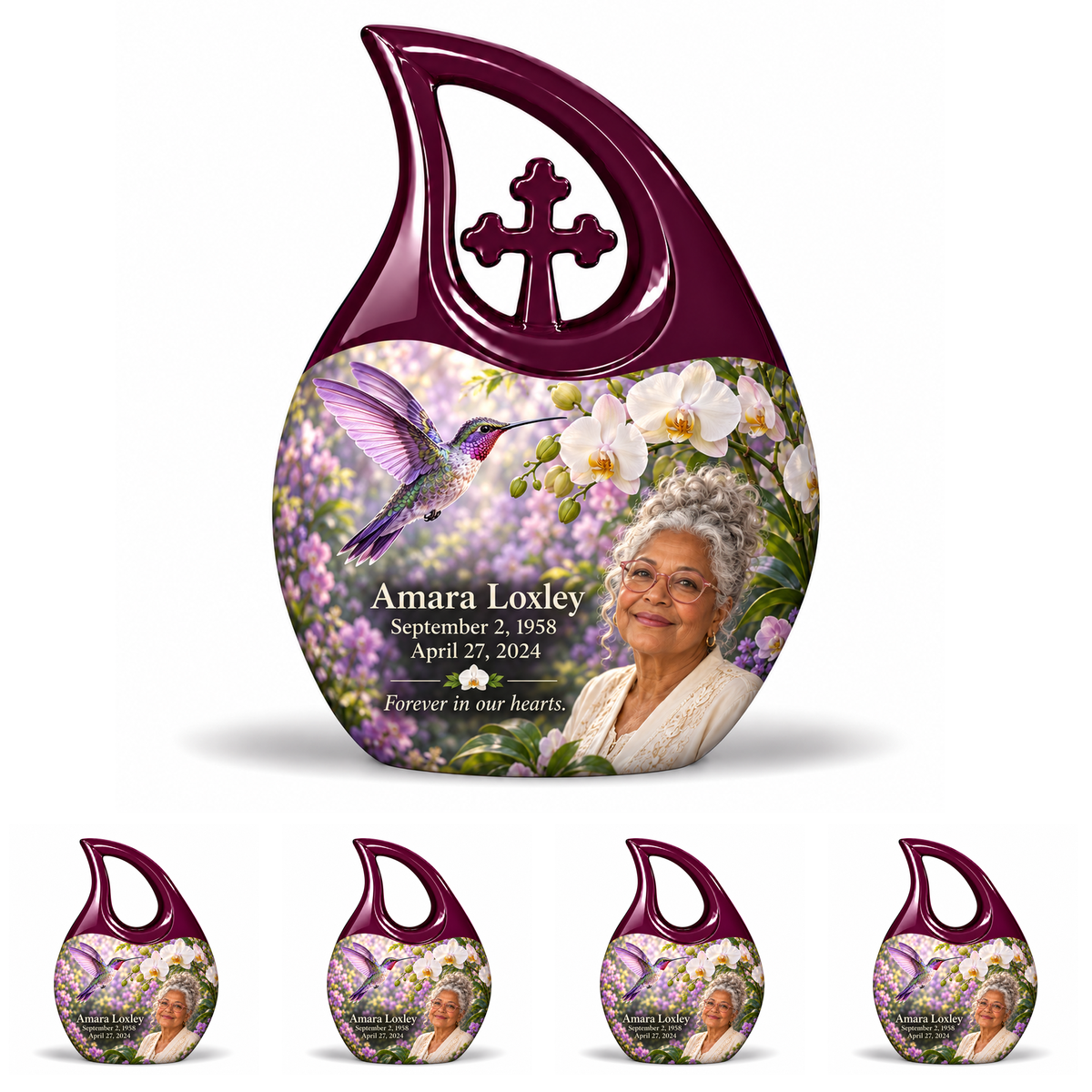 Hummingbird 02 Cross Drop, one large urn with four identical keepsakes: violet hummingbird and white orchids, solid plum large cross loop and four no-cross open loops; Amara Loxley portrait, name and full dates on a white backdrop.