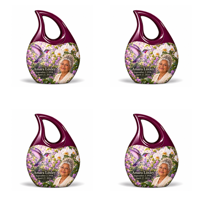Hummingbird 02 Cross Drop, four identical keepsakes: violet hummingbird and white orchids, solid plum open loops without crosses; Amara Loxley portrait, name and full dates on a white backdrop.