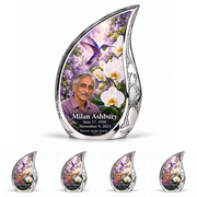 Hummingbird 02 Curved Drop, one large urn with four identical keepsakes: violet hummingbird above white orchids and lilac garden inside a complete engraved silver frame; Milan Ashbury portrait, name and full dates.