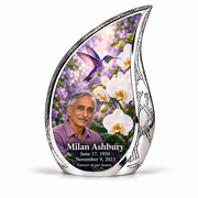 Hummingbird 02 Curved Drop, large urn: violet hummingbird above white orchids and lilac garden inside a complete engraved silver frame; Milan Ashbury portrait, name and full dates.