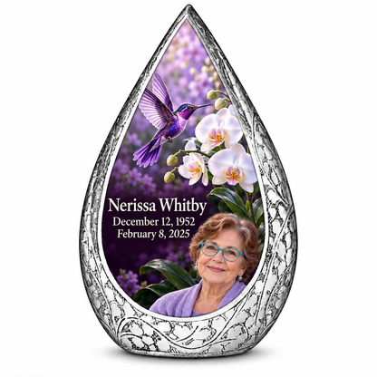 Large silver Straight Drop memorial urn with a violet hummingbird above white orchids on a plum background and Nerissa Whitby portrait, name and full dates.