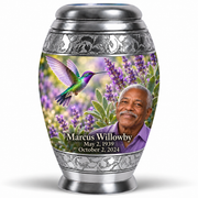 One 10-inch Monar urn with silver engraved bands, green-violet hummingbirds at purple lavender and fictional Marcus Willowby portraits, May 2, 1939 to October 2, 2024.