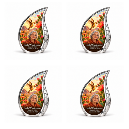 Four identical engraved silver Curved Drop keepsakes with golden hummingbird, desert cactus blooms and Leela Windermere portraits.