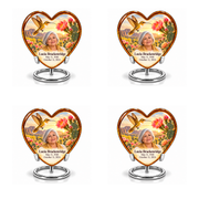 Four identical amber Heart keepsakes with golden hummingbirds, pink cactus blossoms and Lucia Brackenridge portraits on complete silver ring stands.