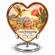 Amber Heart urn on silver ring stand with golden hummingbird, pink cactus blooms and Lucia Brackenridge portrait and full dates.