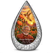 Large Straight Drop memorial urn, golden hummingbird at orange desert cactus blooms, Orson Bellgrove portrait and full memorial dates, white background.