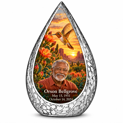 Large Straight Drop memorial urn, golden hummingbird at orange desert cactus blooms, Orson Bellgrove portrait and full memorial dates, white background.