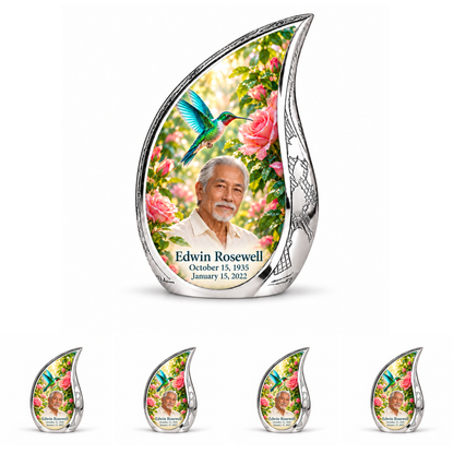 10 inch large Urn with 4 Keepsake 3 Inch Urns; Engraved silver Curved Drop with vivid turquoise and icy cyan hummingbird wings above soft pink roses and green leaves. Edwin Rosewell has a narrow angular East Asian face, swept-back silver hair, small white beard and cream shirt. Dark teal name and October 15, 1935 / January 15, 2022 dates are accurate.