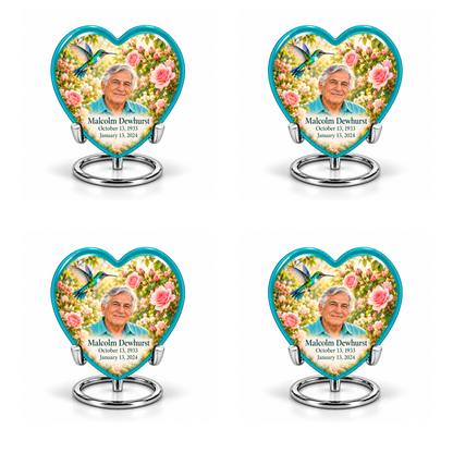 4 Keepsake 3 inch Urns; Glossy turquoise Heart with turquoise-winged hummingbird above soft pink roses and a cream garden. Malcolm Dewhurst has a broad triangular clean-shaven face, curved nose, dark brows, thick swept silver hair and turquoise shirt. Dark teal name and October 13, 1933 / January 13, 2024 dates are accurate.