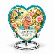 1 Keepsake 3 inch Urn; Glossy turquoise Heart with turquoise-winged hummingbird above soft pink roses and a cream garden. Malcolm Dewhurst has a broad triangular clean-shaven face, curved nose, dark brows, thick swept silver hair and turquoise shirt. Dark teal name and October 13, 1933 / January 13, 2024 dates are accurate.