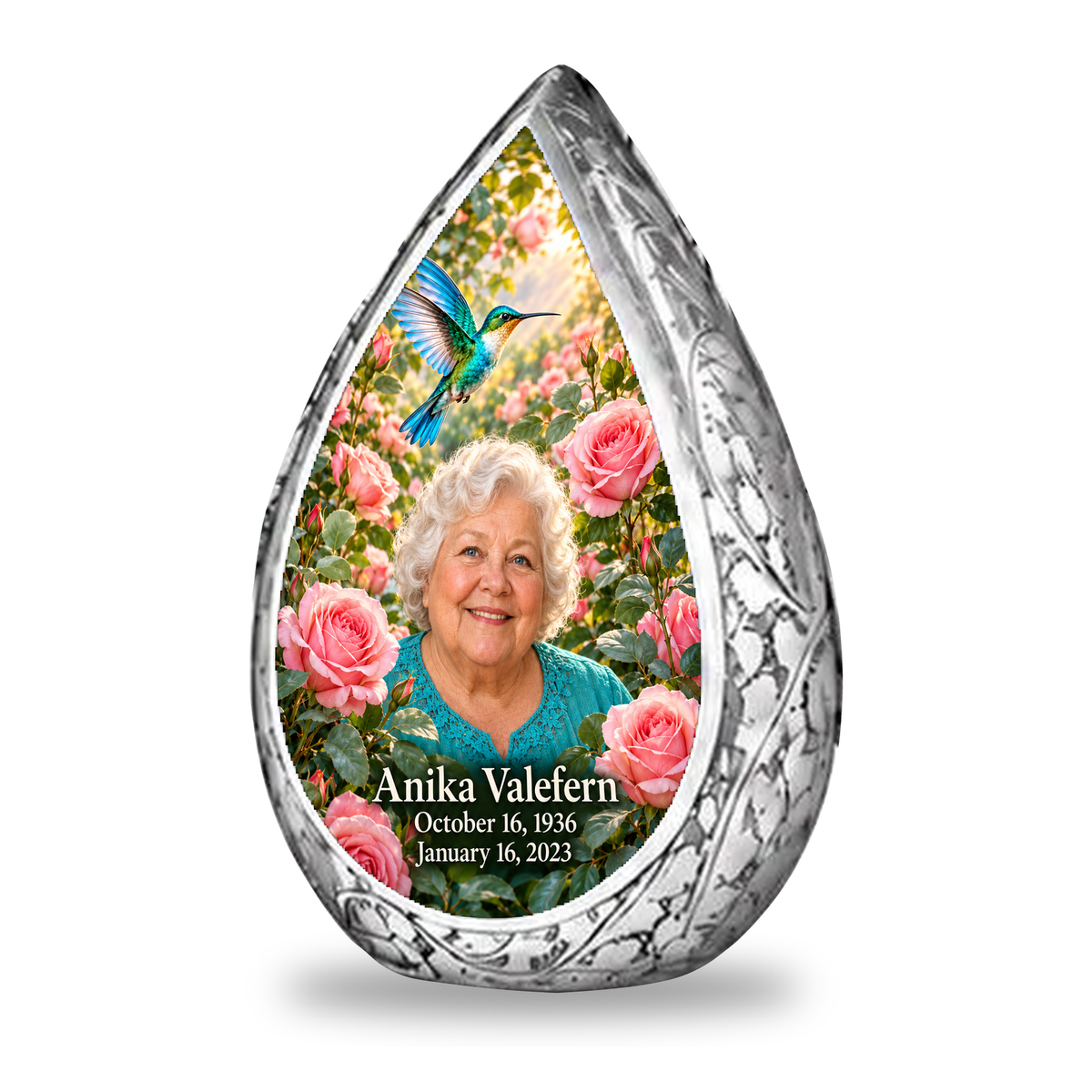1 Keepsake 3 inch Urn Straight Drop memorial urn, turquoise hummingbird among soft pink roses, Anika Valefern portrait and full memorial dates, white background.