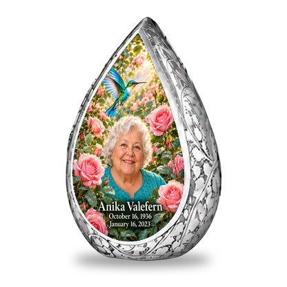 1 Keepsake 3 inch Urn Straight Drop memorial urn, turquoise hummingbird among soft pink roses, Anika Valefern portrait and full memorial dates, white background.