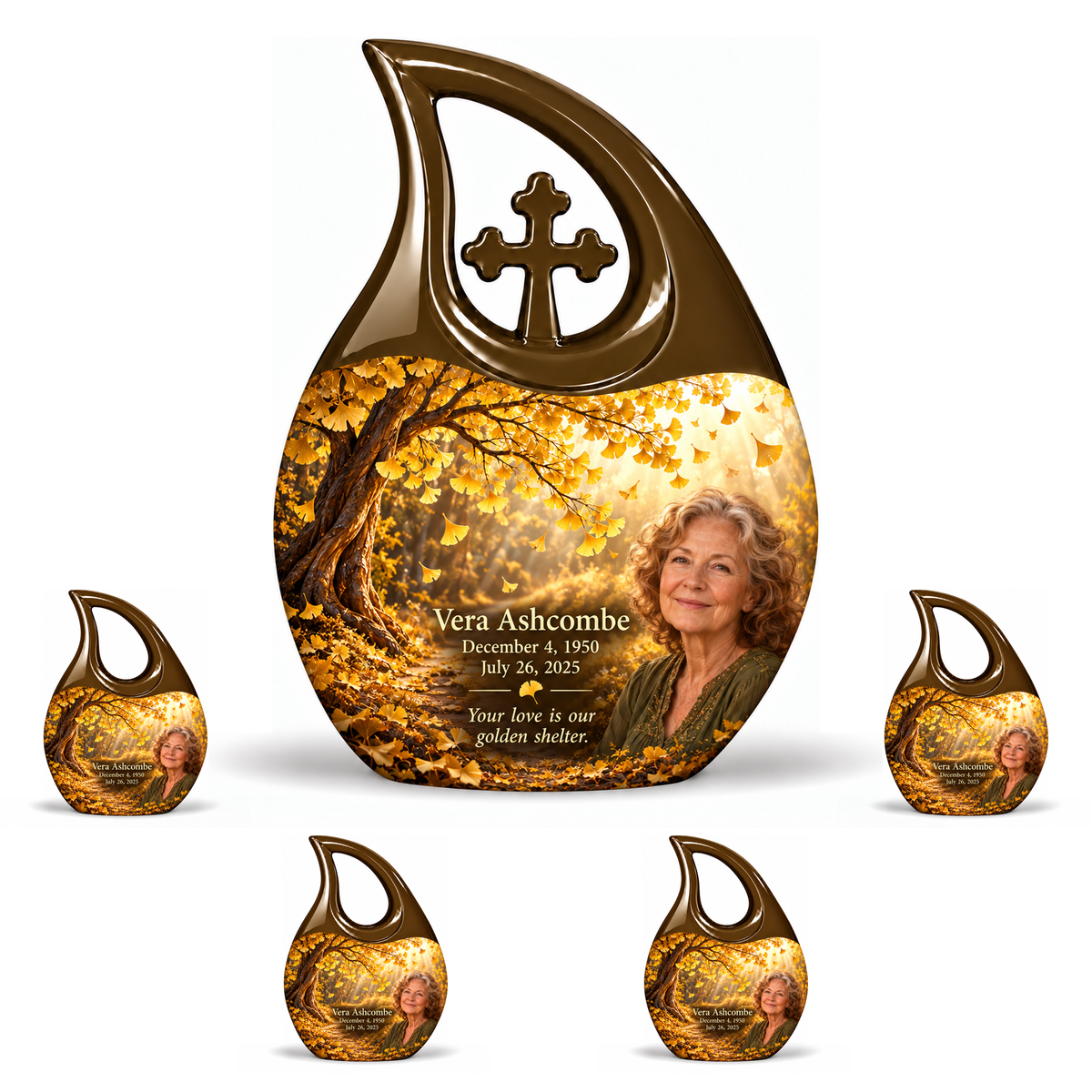 One 10-inch large urn with four matching 3-inch keepsakes, Cross Drop golden-ginkgo woodland-path design with fictional Vera Ashcombe portrait, name and full memorial dates on white background.