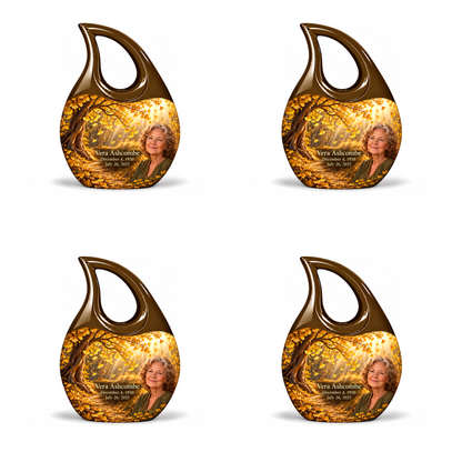 Four identical 3-inch keepsakes, Cross Drop golden-ginkgo woodland-path design with fictional Vera Ashcombe portrait, name and full memorial dates on white background.