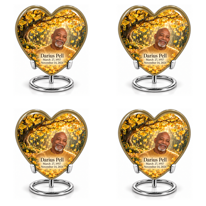 Tree of Life 20 set of four identical Heart keepsakes in two rows, each showing gold ginkgo leaves, fictional Darius Pell portrait and full dates on complete silver ring stands.
